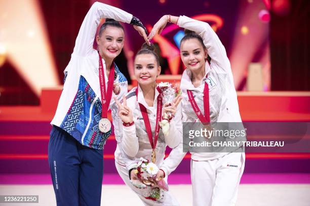Silver medallist Belarus' Alina Harnasko, gold medallist Russia's Dina Averina and bronze medallist Russia's Arina Averina pose during the medal...