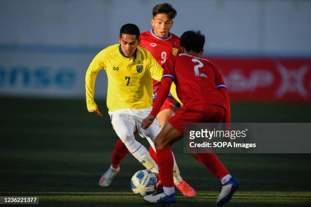 Jakkit Palapon of Thailand and Phoutthavong Sangvilay of Laos are seen in action during the AFC U23 Asian Cup Uzbekistan 2022 Group J qualifying...