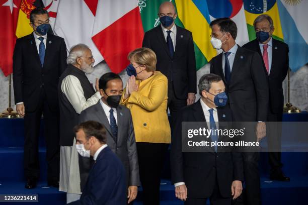 October 2021, Italy, Rome: Indian Prime Minister Narendra Modi greets German Chancellor Angela Merkel as they arrive for the official family photo on...