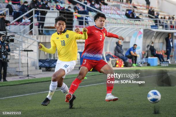 Teerasak Poeiphimai of Thailand and Kittisak Phomvongsa of Laos are seen in action during the AFC U23 Asian Cup Uzbekistan 2022 Group J qualifying...