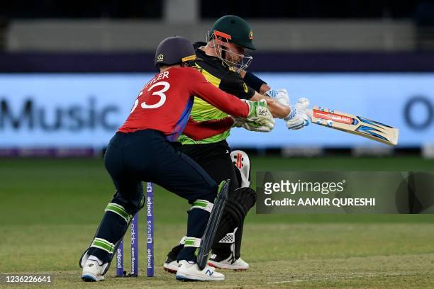 Australia's captain Aaron Finch plays a shot as England's wicketkeeper Jos Buttler watches during the ICC mens Twenty20 World Cup cricket match...