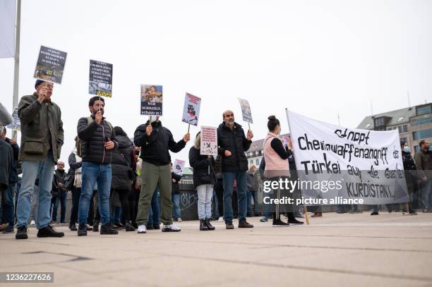 October 2021, Hamburg: Demonstrators display placards reading, among other things, "Stop Turkey's chemical weapons attack on the Kurdistan...