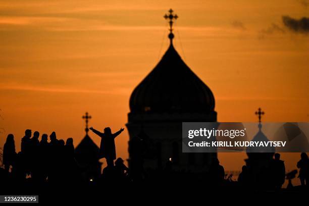 People rest in Zaryadye park in front of the Christ, the Saviour cathedral, the main Russian Orthodox church amid the outbreak of the Covid-19...