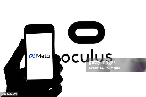 In this photo illustration a Meta logo seen displayed on a smartphone with an Oculus VR logo in the background.