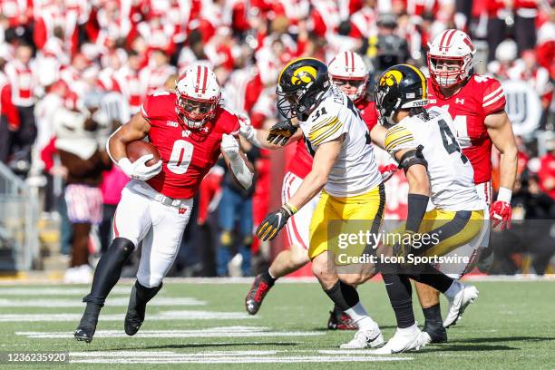 Wisconsin running back Braelon Allen tries to get past Iowa line backer Jack Campbell and Iowa defensive back Dane Belton during a college football...