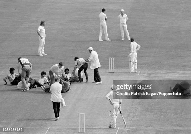 Umpire Dickie Bird ushers pro-Tamil demonstrators off the playing area as play is interrupted by a sit-down protest at the start of the Only Test...
