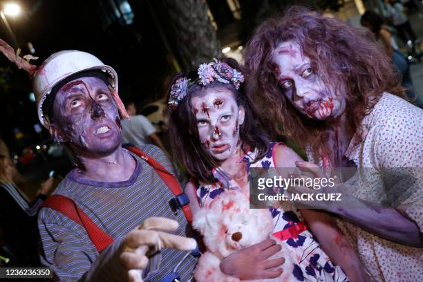 Disguised revellers take part in the annual Zombie Walk during the Halloween celebrations in Tel Aviv on October 30, 2021. - About 100 people took to...