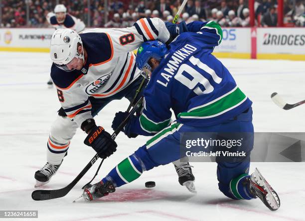 Juho Lammikko of the Vancouver Canucks faces off against Kyle Turris of the Edmonton Oilers during their NHL game at Rogers Arena October 30, 2021 in...