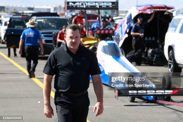 Tony Stewart walks through the staging lanes in front of the car of his fiancée, Leah Pruett Mopar Dodge NHRA Top Fuel Dragster during the Dodge//SRT...