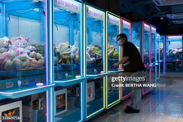 Man plays a claw machine in Hong Kong on October 31, 2021.