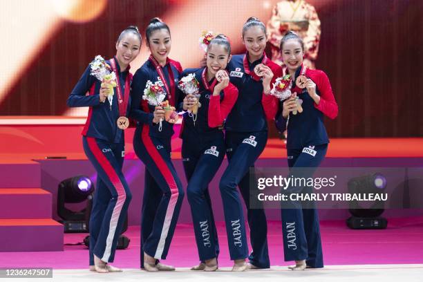 Bronze medallists team Japan pose on the podium after the group three hoops and two pairs of clubs final during the Rhythmic Gymnastics World...