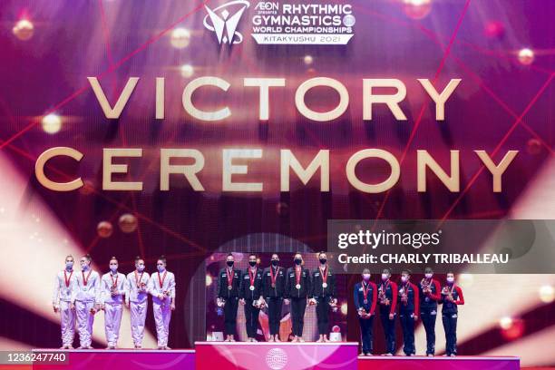 Silver medallists team Russia, gold medallists team Italy and bronze medallists team Japan pose on the podium after the group three hoops and two...