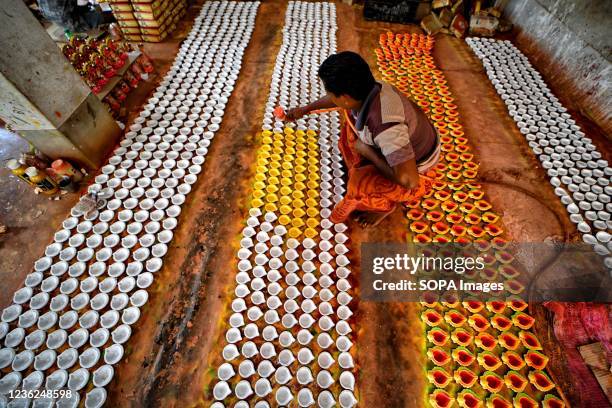 Worker seen coloring the earth lamps ahead of Diwali Festival in India. Deepavali or Dipavali is a four-five day-long festival of lights, which is...