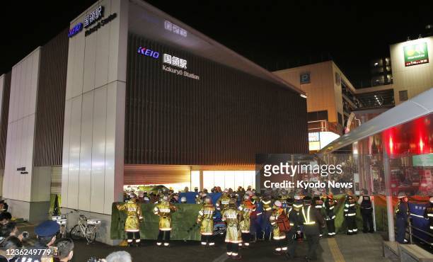 Firefighters gather at Kokuryo Station in Chofu, western Tokyo, on Oct. 31 after a fire broke out on a Keio Line train. Authorities arrested a man...