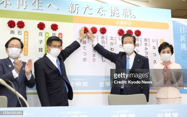 Natsuo Yamaguchi , who heads Komeito, the ruling Liberal Democratic Party's junior coalition partner, attaches a rosette at his party's headquarters...