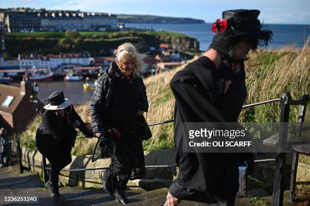 Participants in costume walk up the steps to the Abbey during the biannual 'Whitby Goth Weekend' festival in Whitby, northern England, on October 31,...