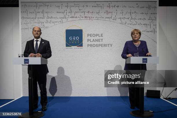 October 2021, Italy, Rome: German Finance Minister Olaf Scholz and German Chancellor Angela Merkel attend the closing press conference of the G20...