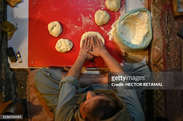 Afghan men prepare Naan bread to sell in a bakery in Kabul city, on October 31, 2021.