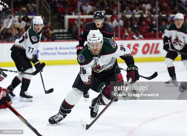 Christian Fischer of the Arizona Coyotes looks to gain possession of the puck during an NHL game against the Carolina Hurricanes on October 31, 2021...