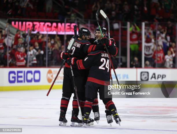 Brett Pesce of the Carolina Hurricanes scores his first goal of the season and celebrates with teammates during an NHL game against the Arizona...