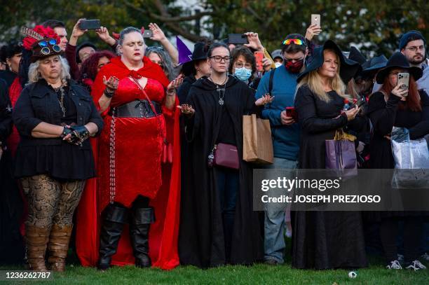 Modern day witches and other participants stand together and hold out their hands during the Witches' Magic Circle in the common on Halloween in...