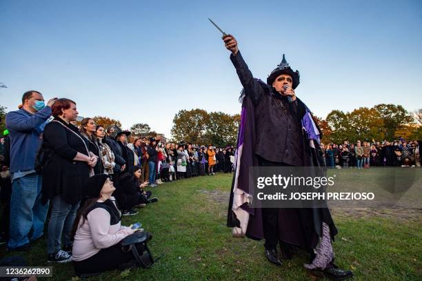 Witch Christian Day holds out a knife as he marches around the circle during the Witches' Magic Circle in the common on Halloween in Salem,...