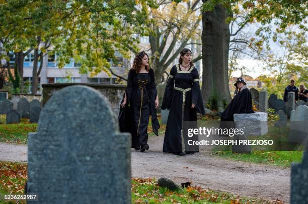 Jamie Allen and Sarah Sylla walk through one of the oldest cemeteries in the US on Halloween in Salem, Massachusetts on October 31, 2021. - The city...