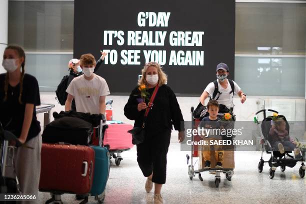 Families walk out of the arrivals hall at Sydney's International Airport on November 1 as Australia's international border reopened almost 600 days...