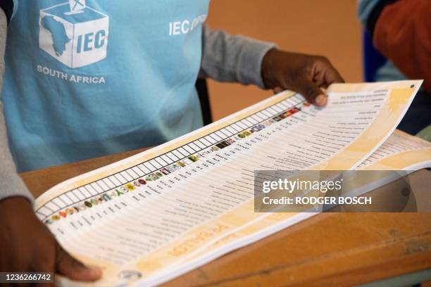 An official with the Independent Electoral Commission folds a ballot paper in a polling station in Langa, near Cape Town, on November 1 during south...