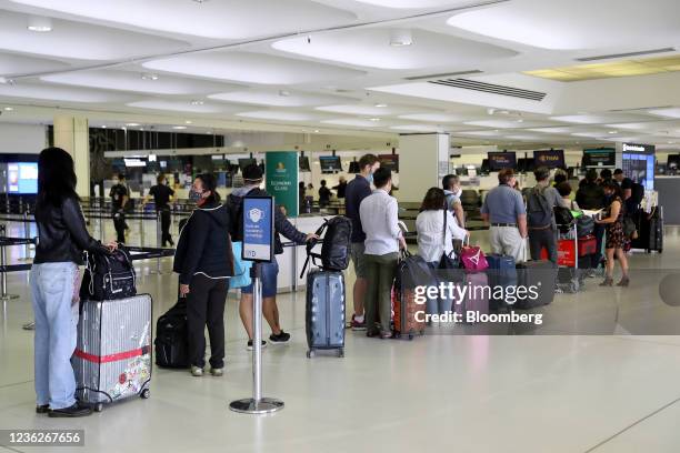 Travelers queue to check in at the departure hall of the international terminal of Sydney Airport in Sydney, Australia, on Monday, Nov. 1, 2021....