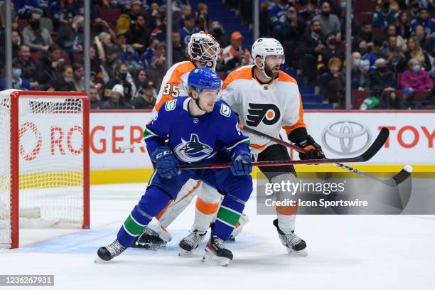 Philadelphia Flyers goaltender Martin Jones and defenseman Keith Yandle defend against Vancouver Canucks right wing Vasily Podkolzin during their NHL...