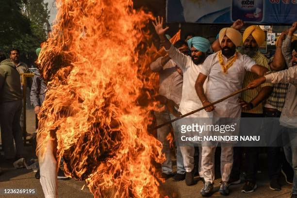Activists from the Shiromani Akali Dal party burn an effigy with pictures of Congress party leaders and Jagdish Tytler who is one of the accused in...