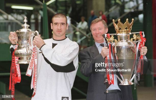 12th May 1996; Manchester United manager Alex Ferguson and Eric Cantona with the FA Cup and Premiership trophy on their arrival at Manchester's...