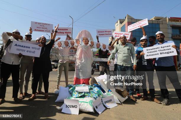 Traders and online sellers burn an effigy of Amazon founder Jeff Bezos during their protest against MNC e-commerce brands, in Jaipur, Rajasthan,...