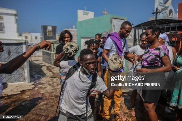 People take part in a ceremony in honor of the Haitian voodoo spirit of Baron Samedi and Gede at the national cemetery of Port-au-Prince, Haiti on...