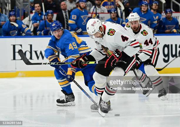 St. Louis Blues center Ivan Barbashev reaches in to get the puck away from Chicago Blackhawks defenseman Seth Jones during a NHL game between the...