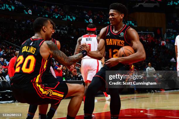 De'Andre Hunter of the Atlanta Hawks helps up his teammate during the game against the Washington Wizards on November 1, 2021 at State Farm Arena in...