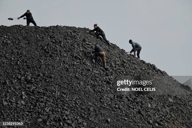 Workers sort rocks near a coal mine in Datong, China's northern Shanxi province on November 2, 2021.