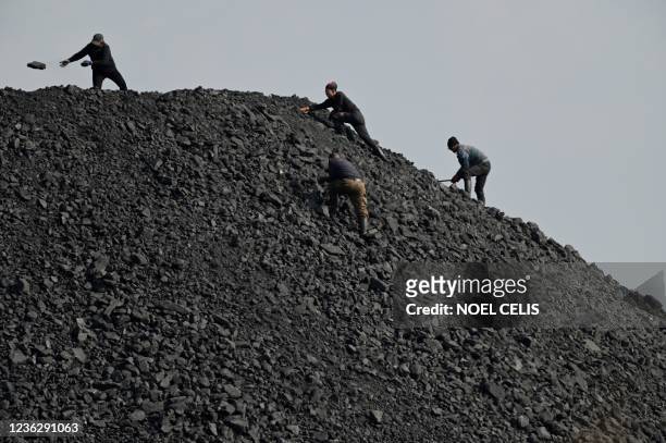 Workers sort rocks near a coal mine in Datong, China's northern Shanxi province on November 2, 2021.
