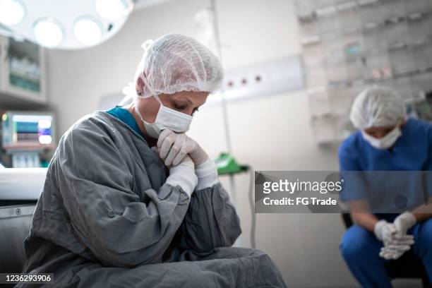 worried healthcare coworkers at operating room in hospital - covid sadness stock pictures, royalty-free photos & images