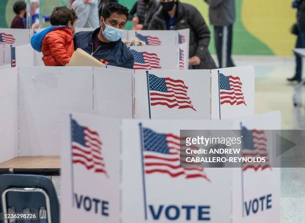 Man waits to cast his ballot at George Marshall High School on election day in Falls Church, Virginia on November 2, 2021 - With the eyes of America...