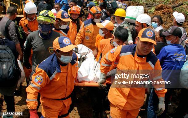 Emergency workers carry a body out of the scene where a mudslide buried two houses in Mallama, Narino province, Colombia, on November 2, 2021. - At...