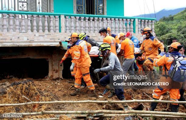 Emergency workers carry a body out of the scene where a mudslide buried two houses in Mallama, Narino province, Colombia, on November 2, 2021. - At...