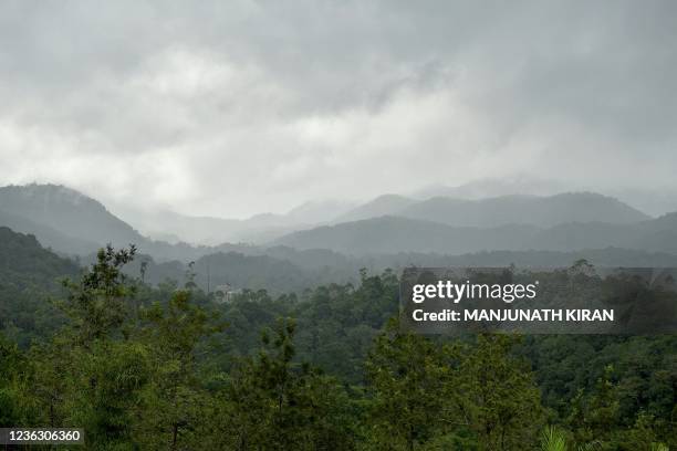 In this photograph taken on September 16 rain clouds loom over a large swathe of forest covering the Western Ghat mountains, in Kerala's Wayanad...