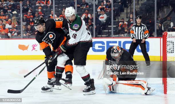 Goaltender Carter Hart of the Philadelphia Flyers swallows the puck in his equipment as Justin Braun battles for position with Andrew Ladd of the...