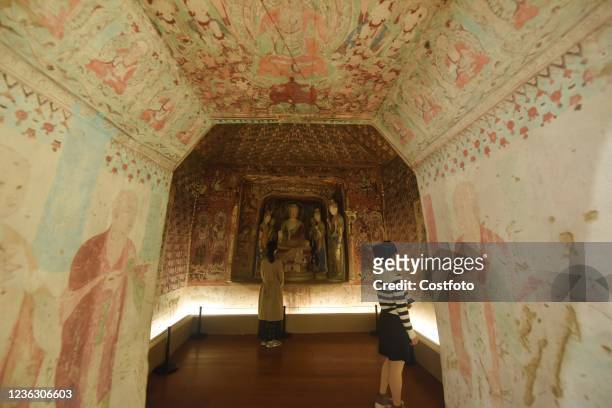 Visitors look at cave 57 of Dunhuang Mogao Grottoes reproduced using 3D digital printing restoration technology at the Museum of Art and Archaeology...