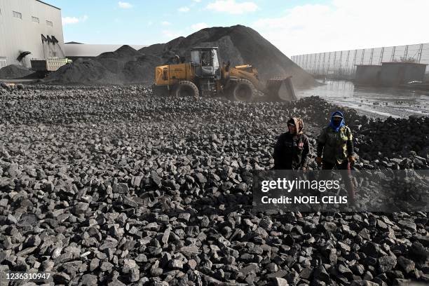 Workers sort coal near a coal mine in Datong, China's northern Shanxi province on November 3, 2021.