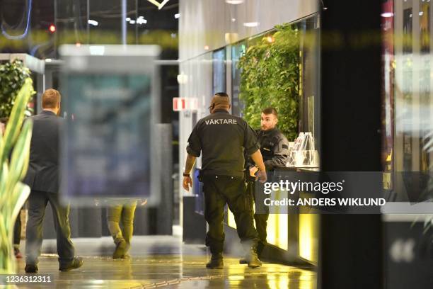 Security guards are seen through the glasses in the concert hall "Uppsala Konsert & Kongress" in Uppsala, Sweden, on November 2, 2021. - Two people...