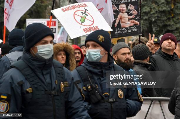 Policemen stay in guard as anti-vaxxers protesters stage a protest against the Covid quarantine restrictions, outside the Ukrainian parliament in...