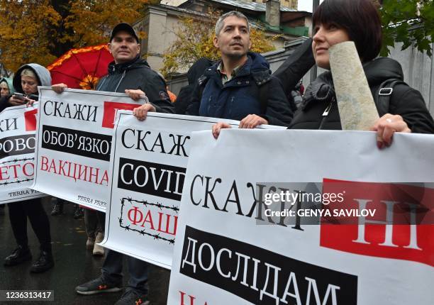 Anti-vaxxers protesters hold placards reading "Say "No" to Covid genocide!", "Say "No" to mandatory vaccinations!" and "Say "No" to experiments on...